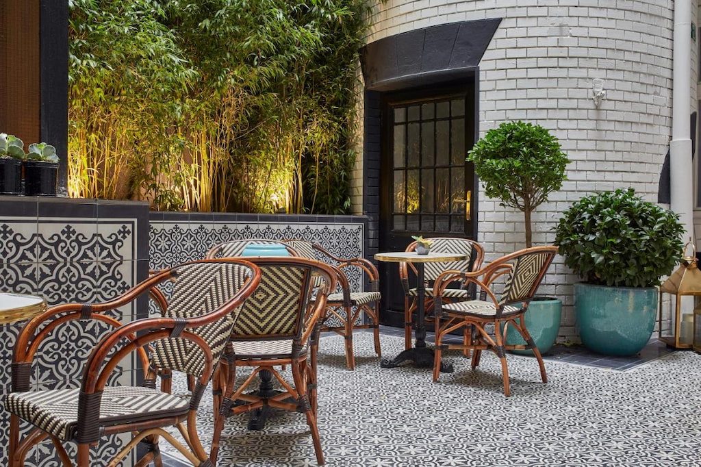 Rustic style chairs in the courtyard of Hotel Collect surrounded by plants