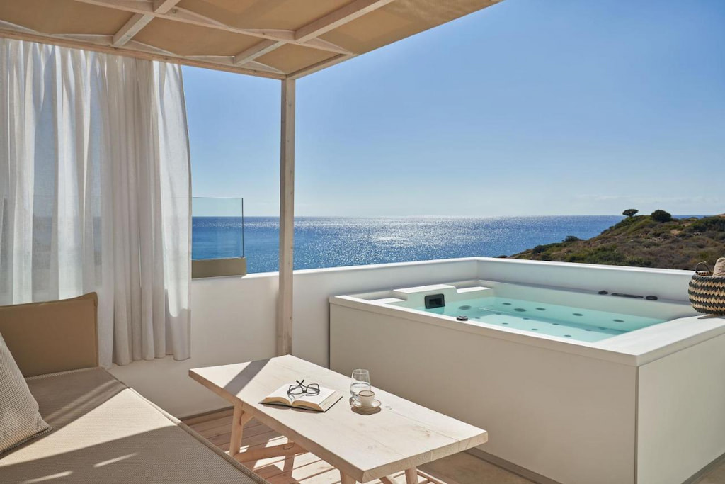 A private pool near a wooden table with an amazing view of the Aegean Sea from the terrace