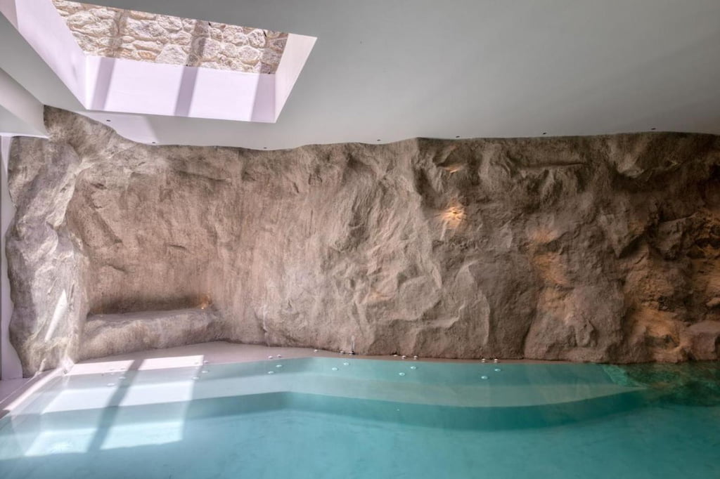 View of the private pool with unique walls and a small opening on the ceiling