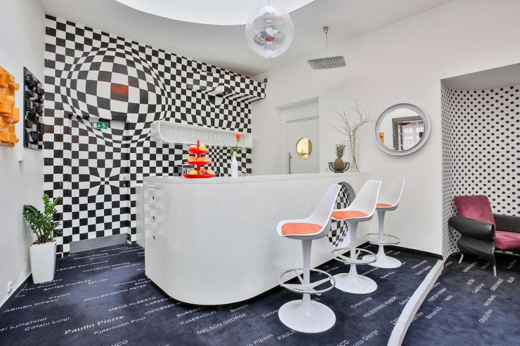 A checkered-design wall near the bar counter with white high chairs 