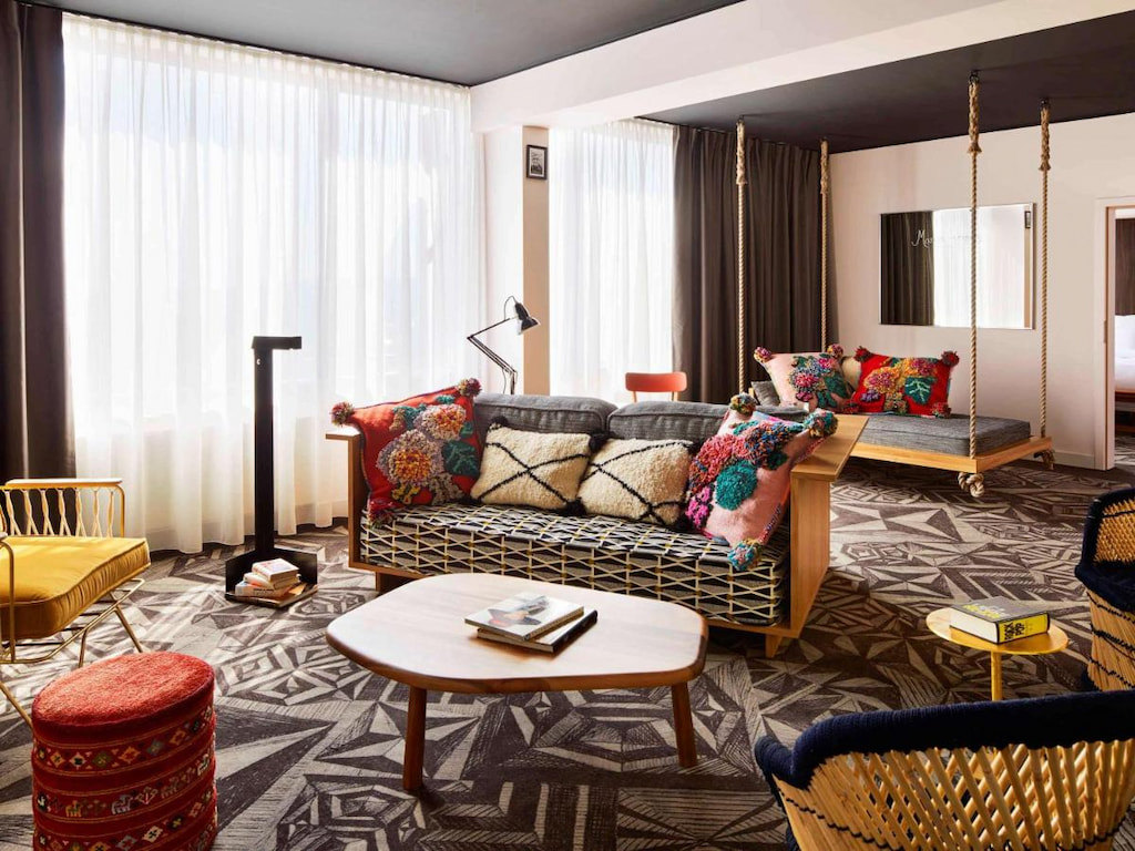 A wide living room area with unique sofa and chairs with colorful pillows in one of the best boutique hotels in Prague