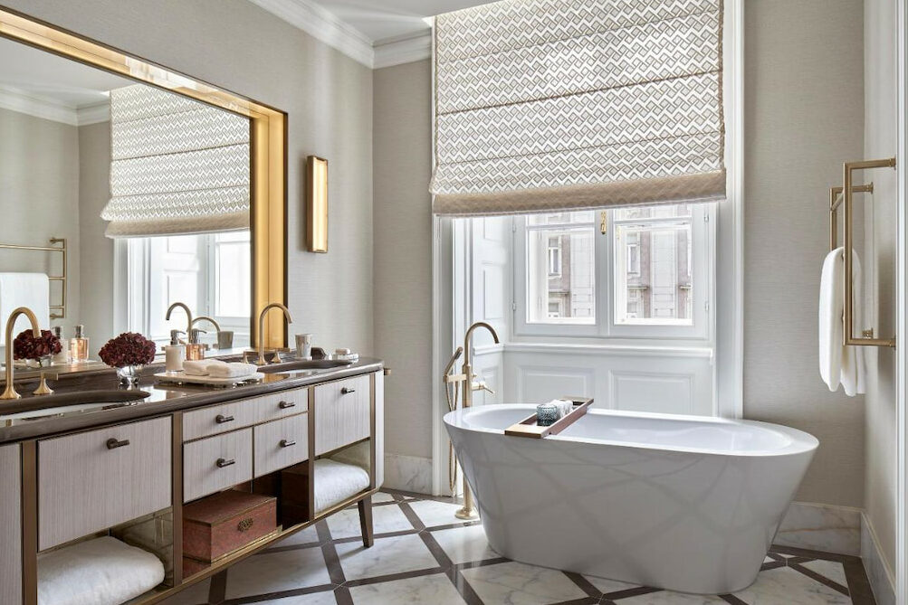 An elegant bathroom with a luxurious white tub near a huge vanity mirror
