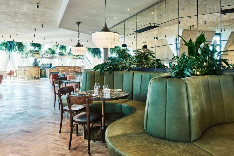 Green curved couch in an on-site restaurant with mirror walls