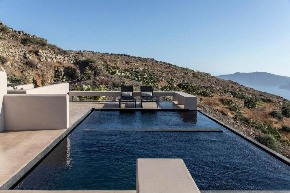 An elegant private pool with black accents and a perfect view of the mountains and the sea