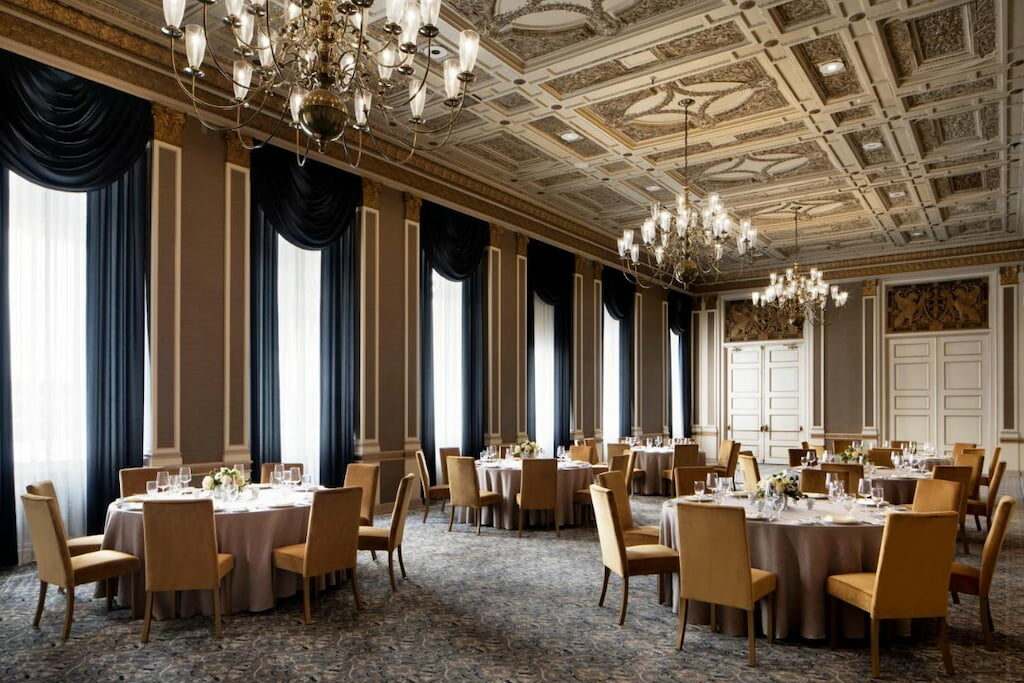 View of the luxurious on-site restaurant with yellow chairs in a high ceiling room
