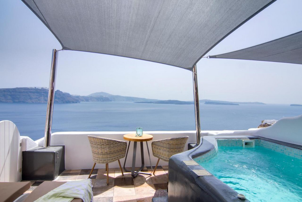 A private pool on the balcony near two accent chairs with the view of the sea