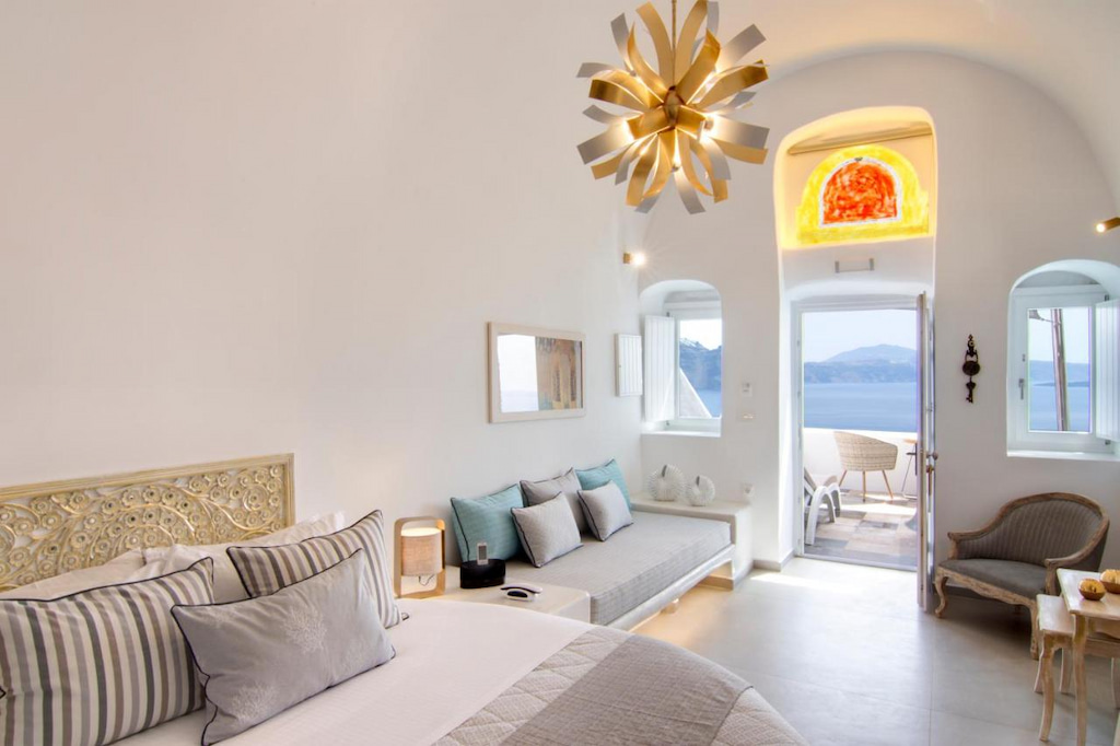 A flower-like lamp hanging in the middle of the room in one of the villas in Oia Santorini