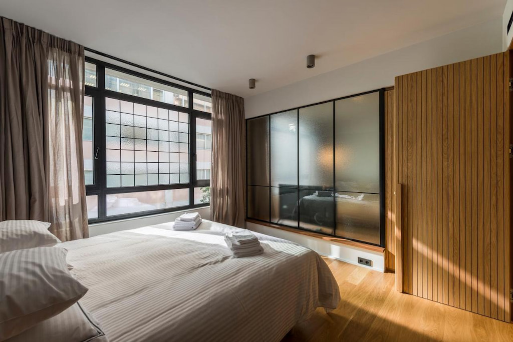 A huge mirror wall in front of the bed beside the window