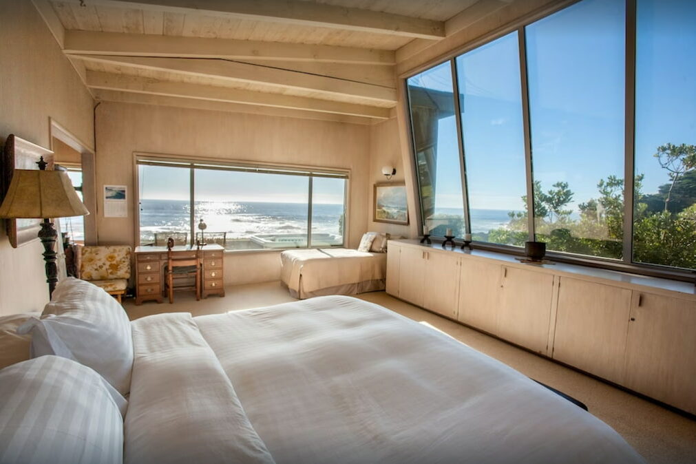 A bedroom with a beautiful view of the ocean from its window