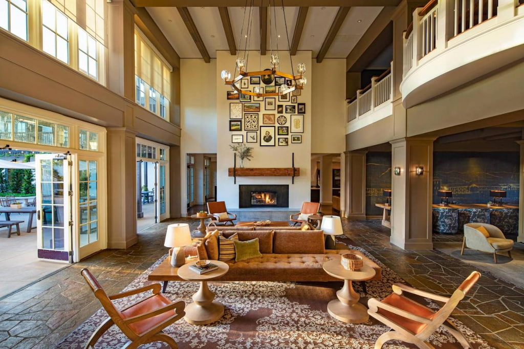 One of the best boutique hotels in Napa Valley's lounge area with high-ceiling and multiple chairs and tables near the wall filled with picture frames. 