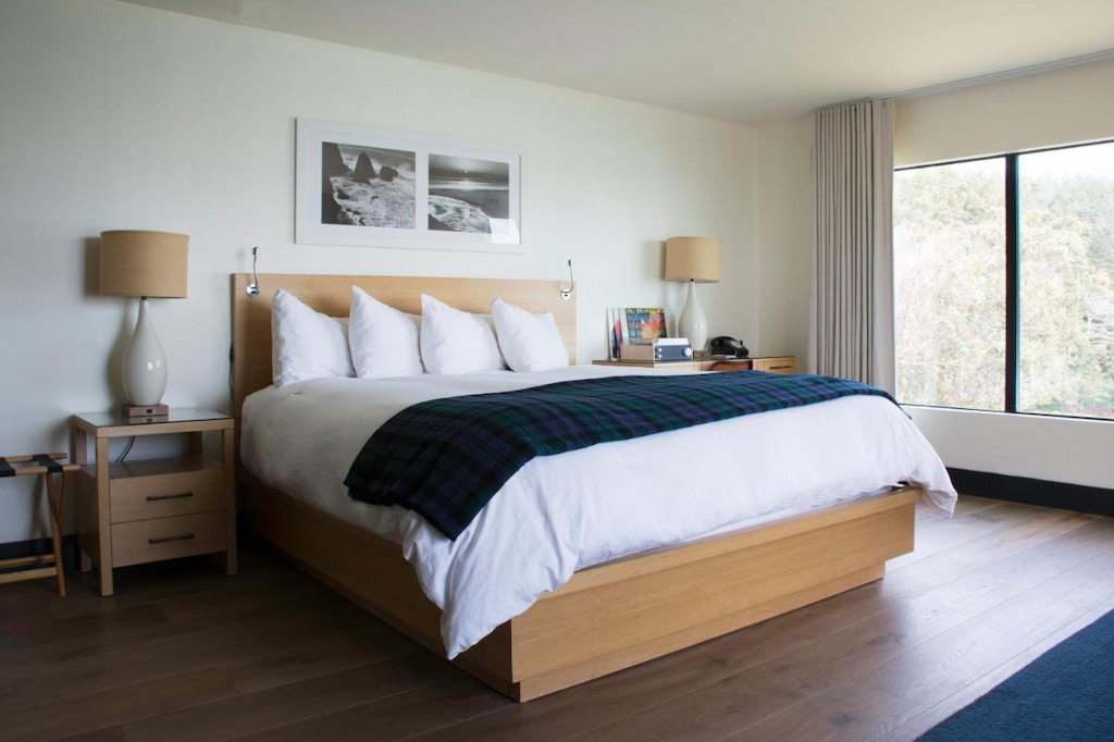 View of a luxury room with king size bed near the window in one of the best boutique hotels in Northern California Coast.