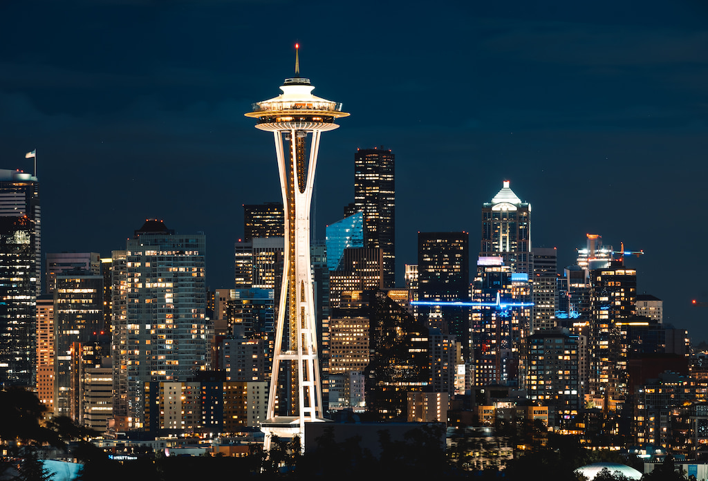 Seattle space needle at night with skyline behind
