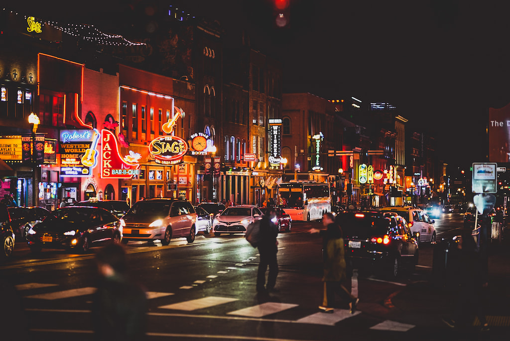 storefronts lit up at night in Nashville puns