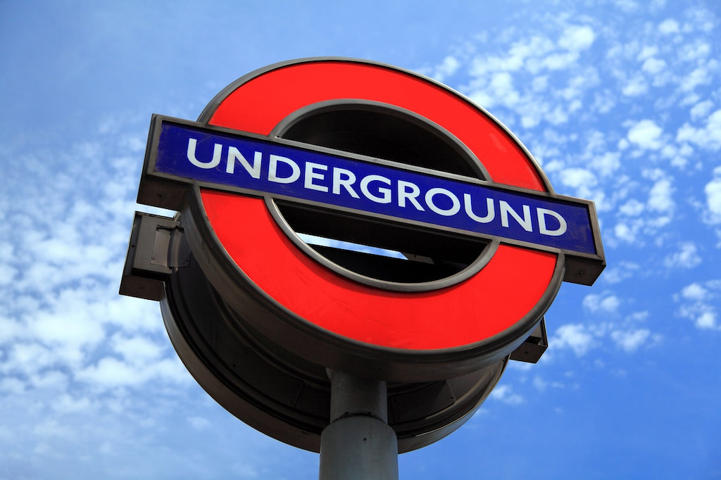 red and blue sign that says underground, common in all major England cities