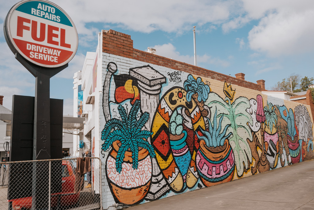 colourful mural on a brick wall with a circular sign saying 'fuel' on it