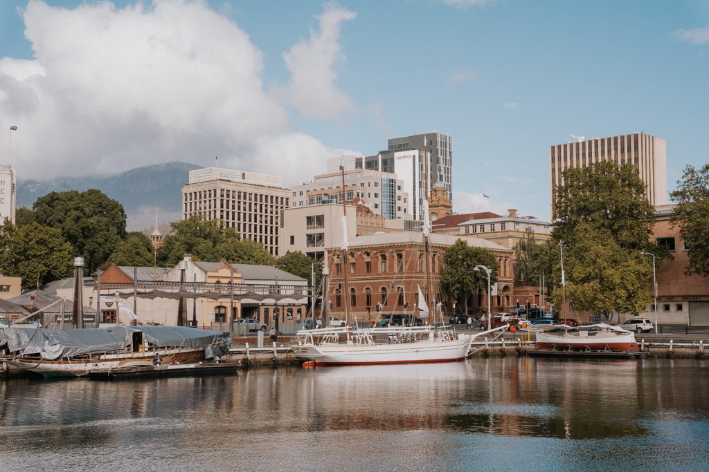 sail boats float in front of a mid of heritage and modern buildings in Hobart