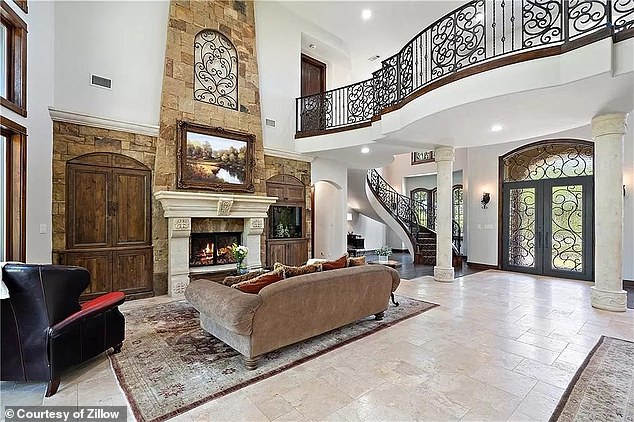 The house has a double-height entrance hall and living room, with an open fireplace