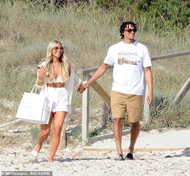 Low-key: Matching his glamorous girlfriend, Trent cut a casual figure in a simple white T-shirt and camel shorts as he strolled along the beach with Hannah
