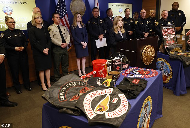 17 members and supporters of the Hells Angels biker gang were arrested in connection to a racially-motivated attack in San Diego in June. Pictured: San Diego County District Attorney Summer Stephan presents Hells Angels paraphernalia during a press conference on Monday