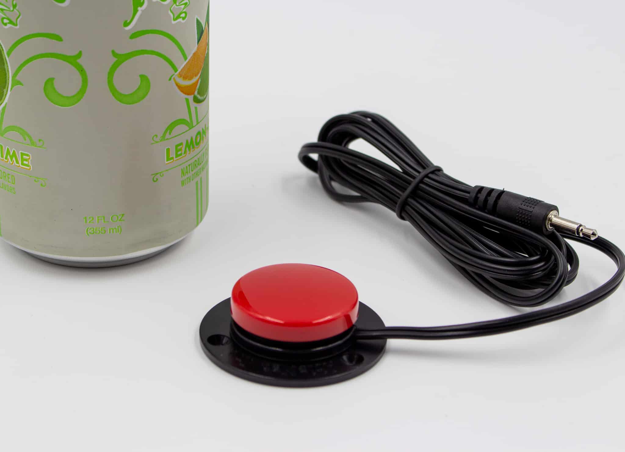 Small red switch next to a standard soda can. The switch is about half the diameter of the soda can. It has a black wire. 
