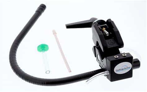  A black, plastic clamp attached to a black straw. A small clear tube and a smaller clear tube with a green base are also pictured.  