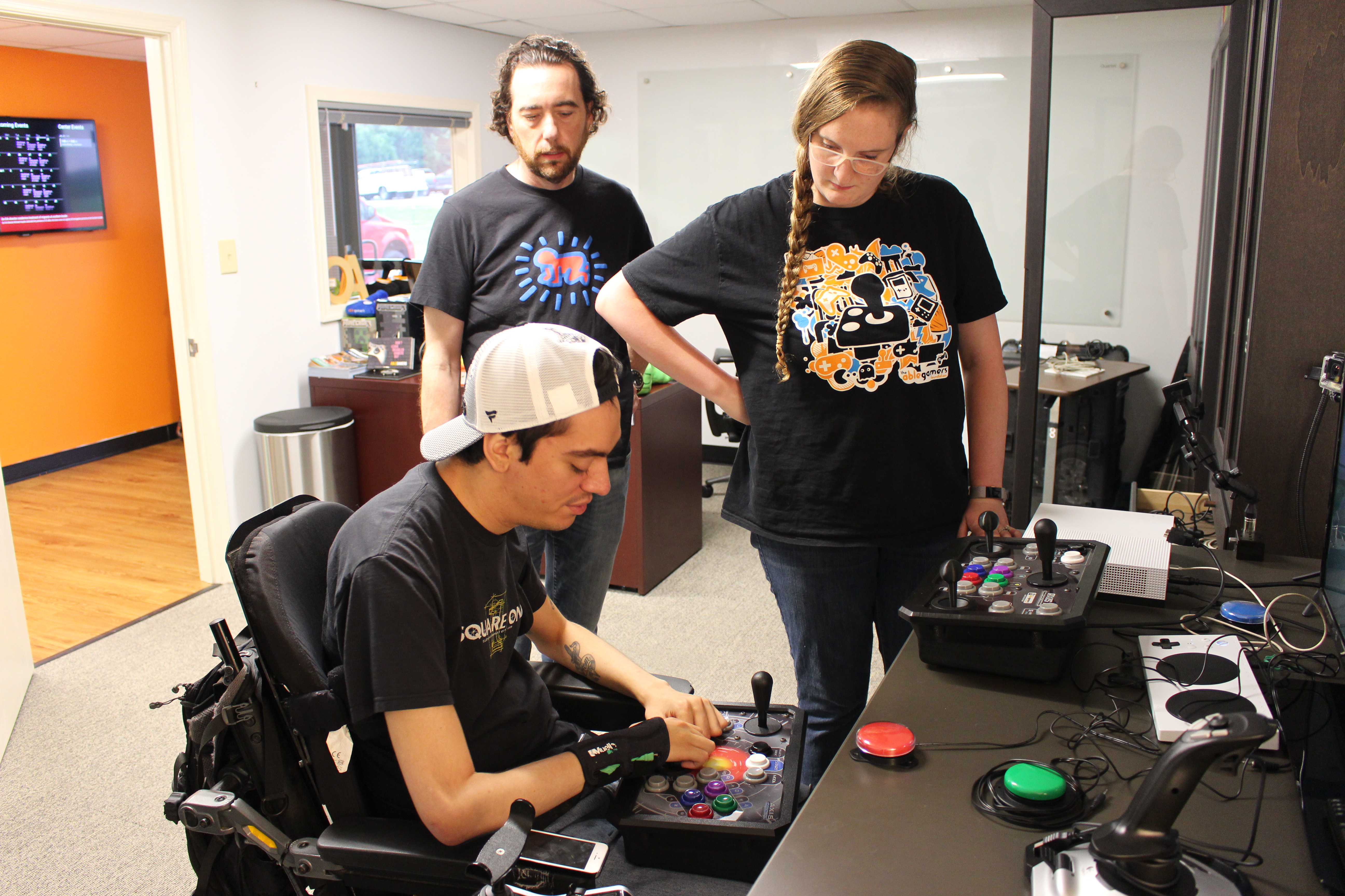 Mark Barlet and Jessie Hall watching a player use an Axis controller.