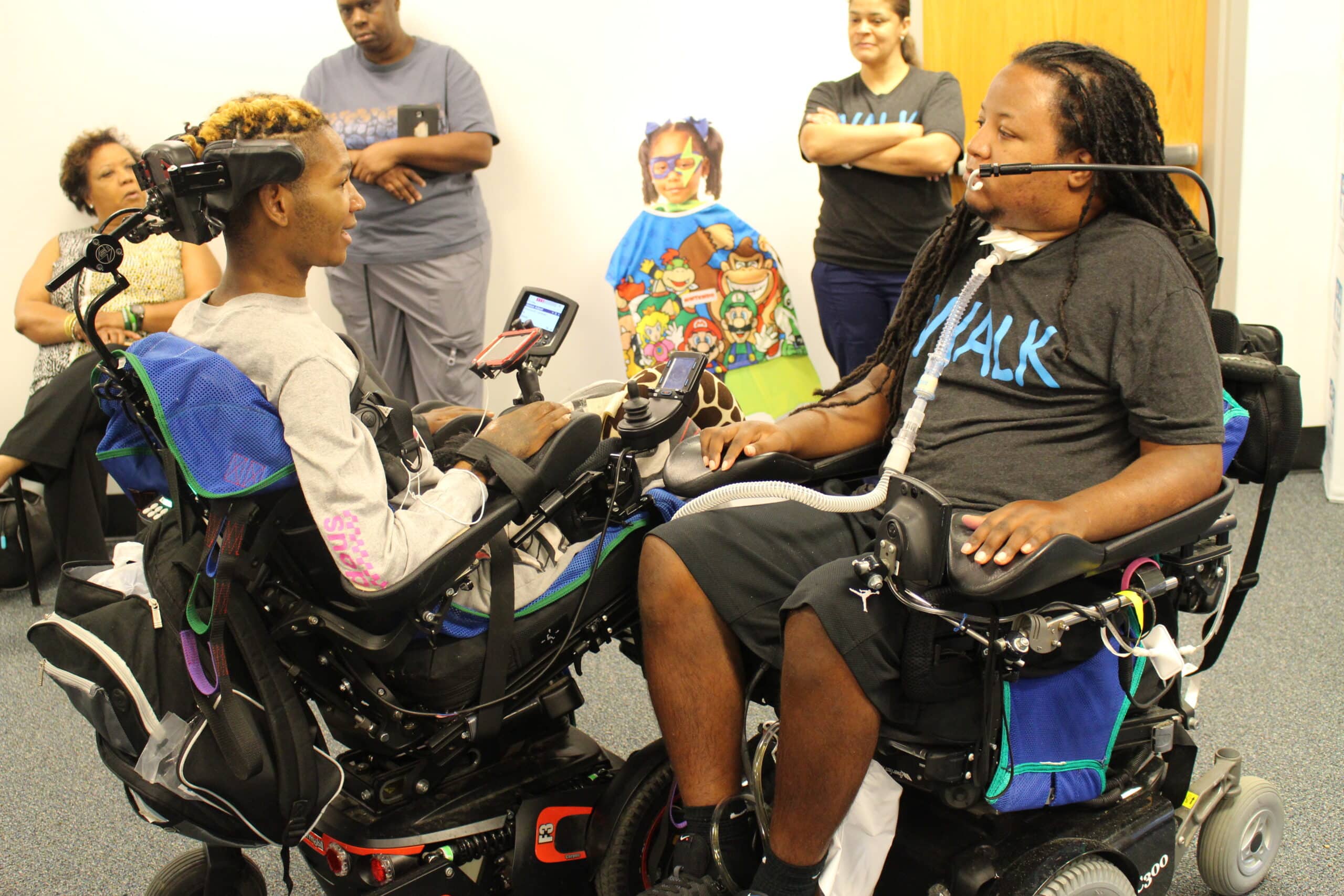 To African-American power wheelchair users, meeting and challenging each other to a game using a quadstick.