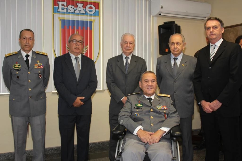 Bolsonaro (à dir) em pé ao lado de quatro generais do exército. À sua frente, em uma cadeira de rodas, está o general Villas Bôas