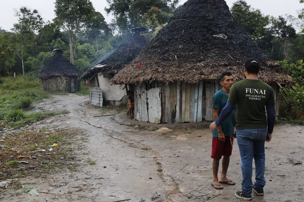 Servidor da Funai conversa com indígena yanomami em aldeia