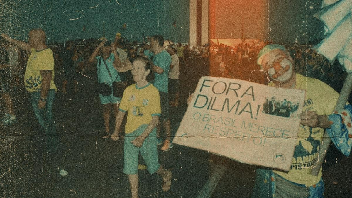 Manifestação pró-impeachment de Dilma Rousseff em Brasília, na imagem é possível ver um homem vestido de palhaço mostrando um cartaz escrito ''Fora Dilma'' , e ao fundo pessoas vestidas com a camiseta da seleção brasileira