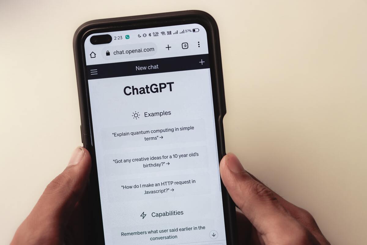 Pessoa segura celular com as mãos enquanto usa a ferramenta de inteligência artificial ChatGPT