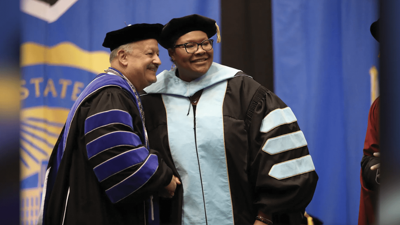 Cherina Betters (right) is congratulated by CSUSB President Tomás D. Morales upon receiving her Ed.D. degree.