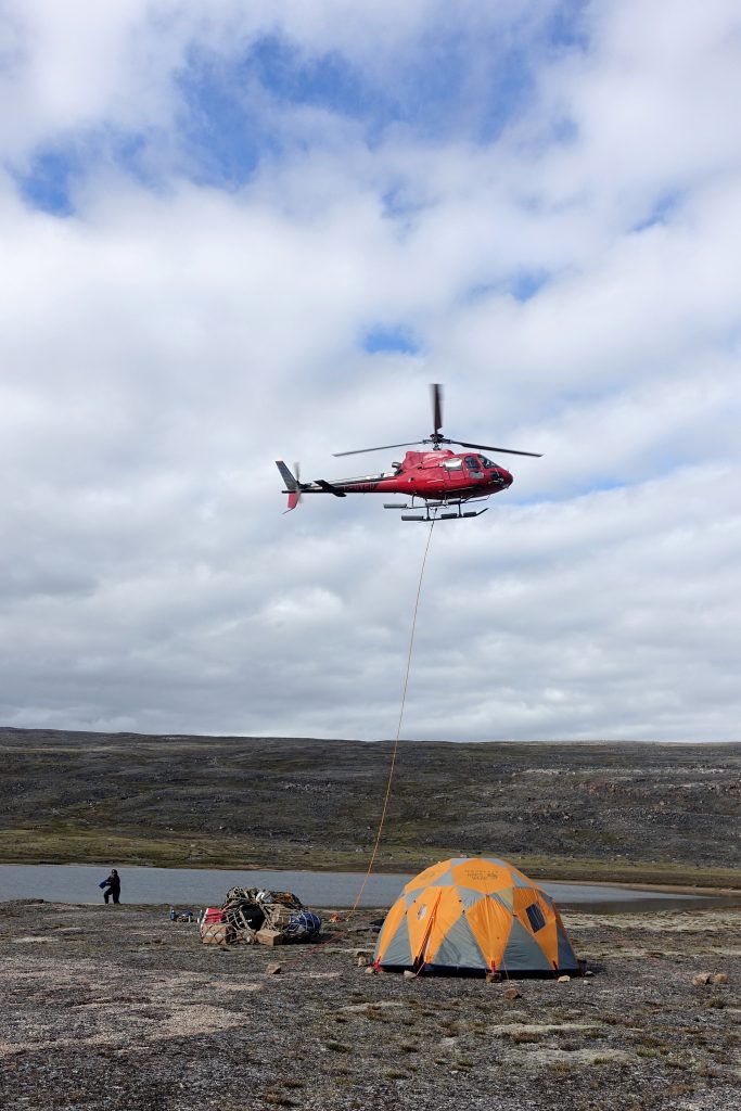 A helicopter hovering over a tent.