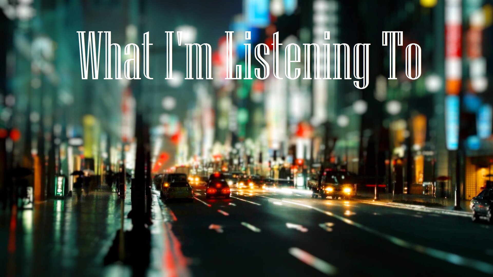 Blurred photo of a city street at night superimposed with the words "What I'm Listening to"