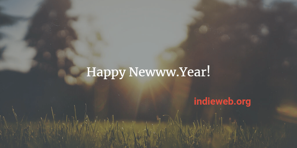 dreamy view of grass and a forest through which the sun is rising superimposed with the text "Happy Newww.Year! indieweb.org"