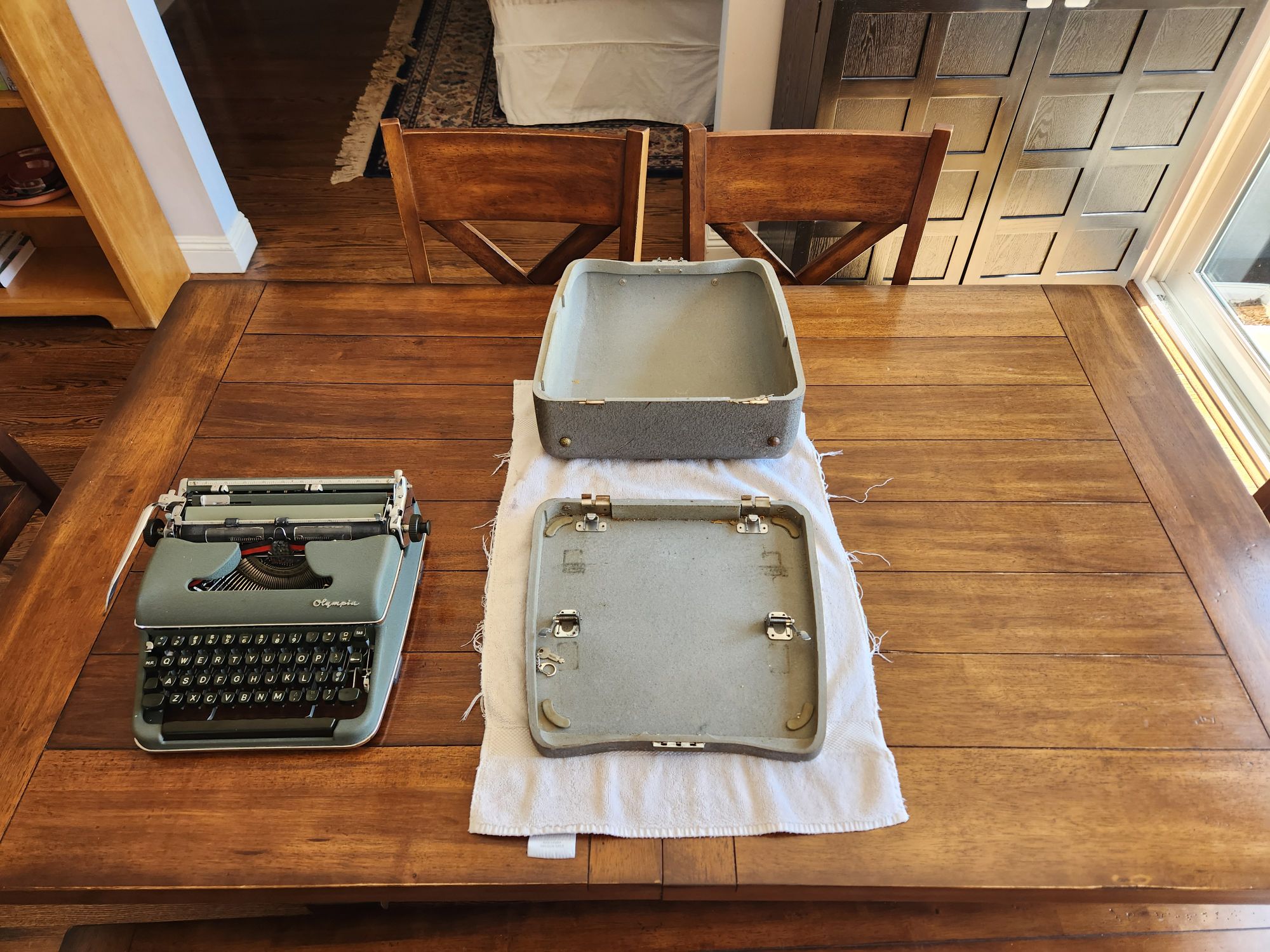 The typewriter has been removed from the case and sat on the right side.