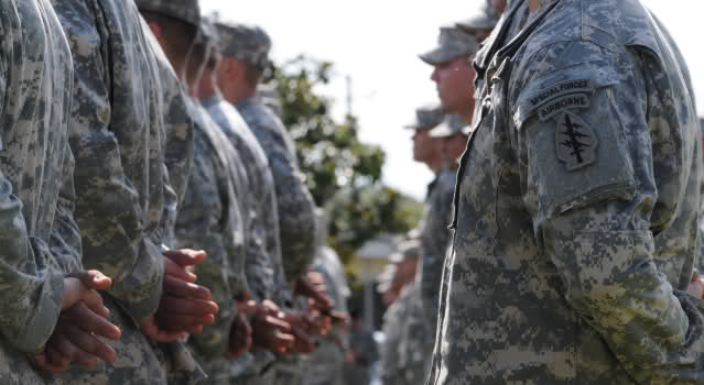 Soldiers stand in formation, preparing to don their Green Berets for the first time, during a Regimental First Formation ceremony. (Photo provided by USAJFKSWCS Public Affairs)