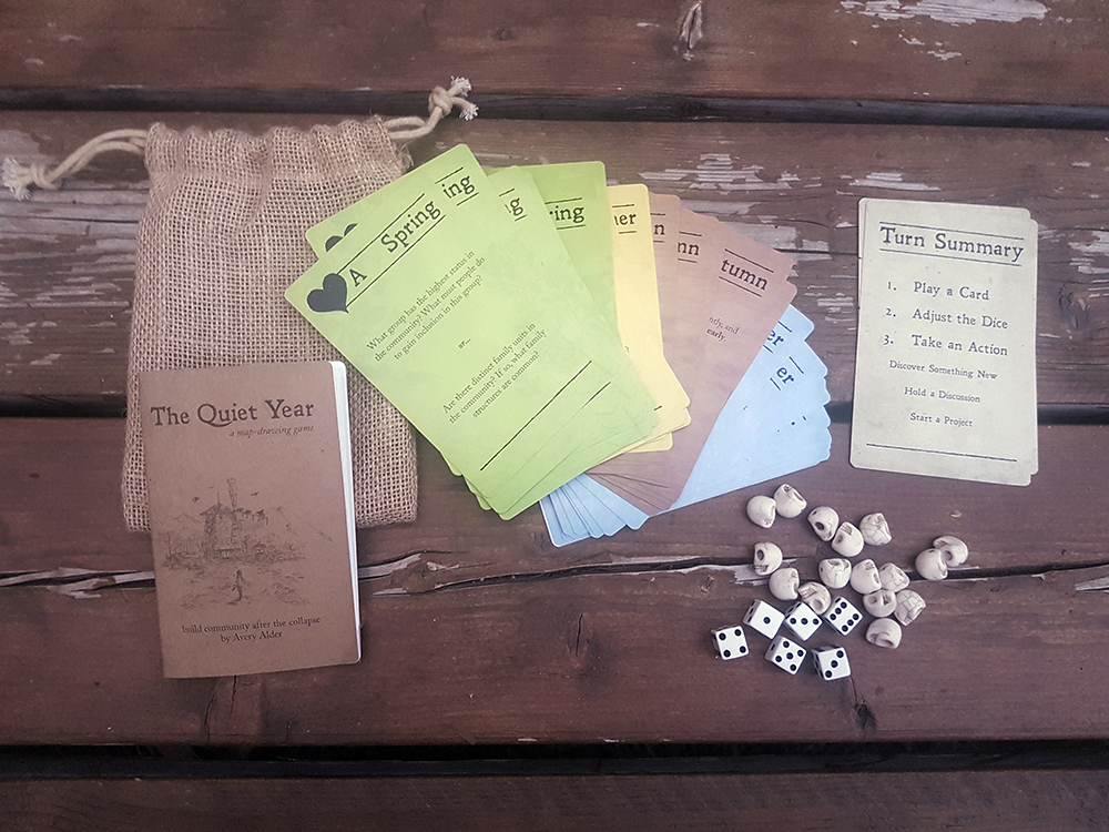 A small burlap bag, next to its unpacked contents: a booklet, cards, dice, and tokens.