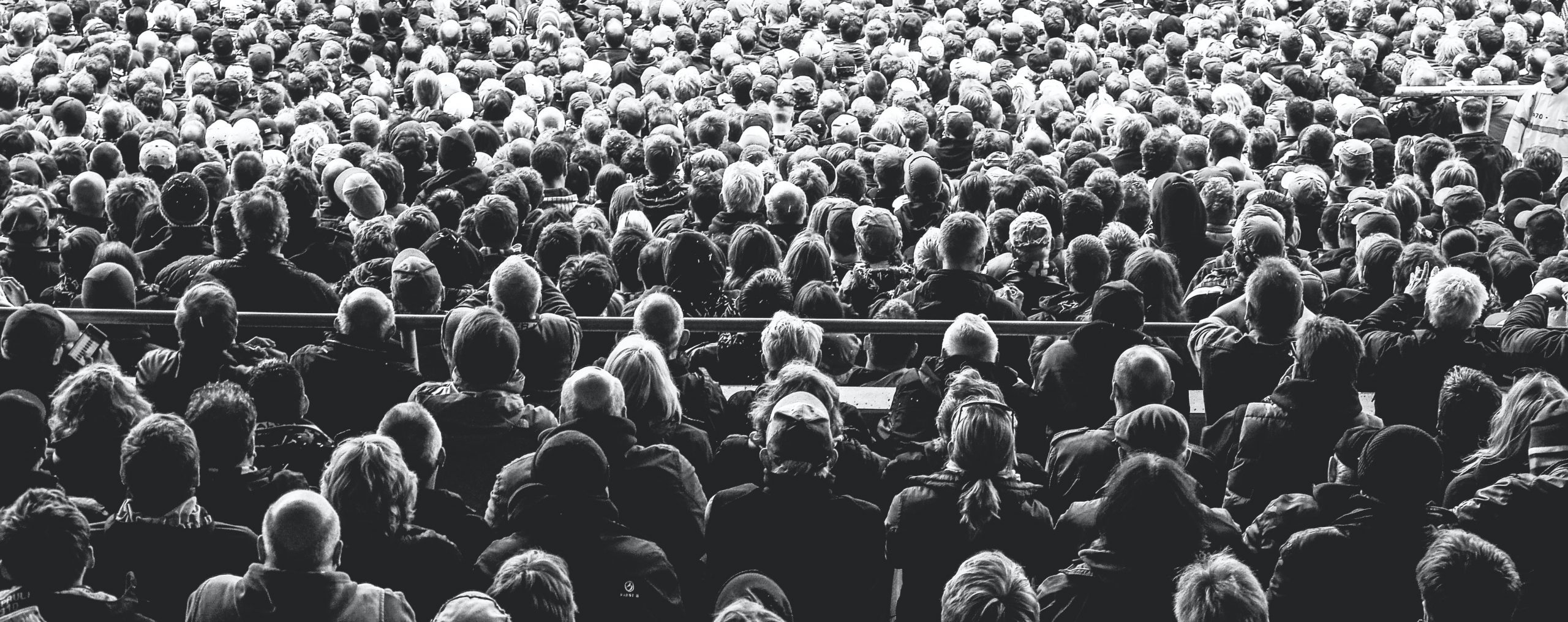 A large crowd is shown in black and white.