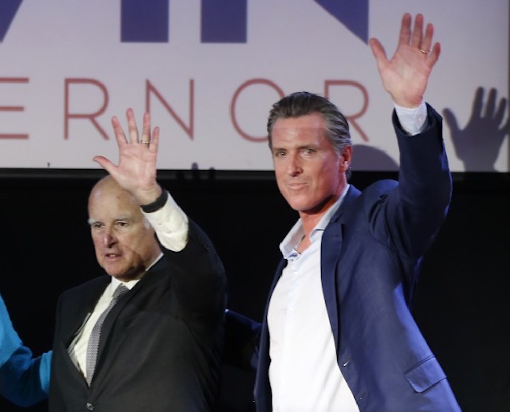 Former Gov. Jerry Brown and then-Lt. Gov. Gavin Newsom wave to the crowd at Newsom's final gubernatorial campaign stop on Nov. 5, 2018, in San Francisco