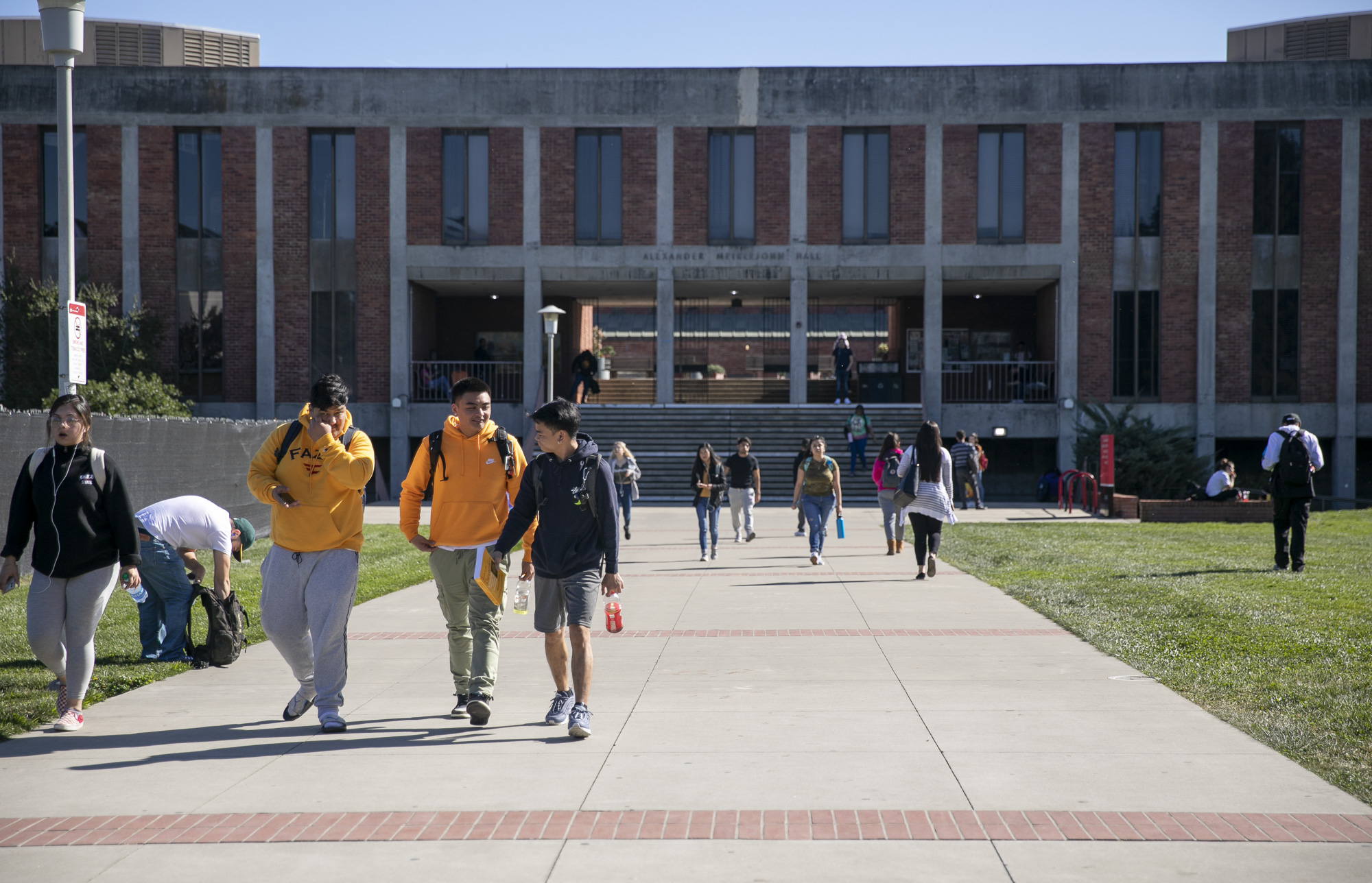 Students walk near Meiklejohn Hall at California State University East Bay. Al Cal State campuses will begin requiring and ethnic studies course for graduation under a new law. Photo by Anne Wernikoff for CalMatters