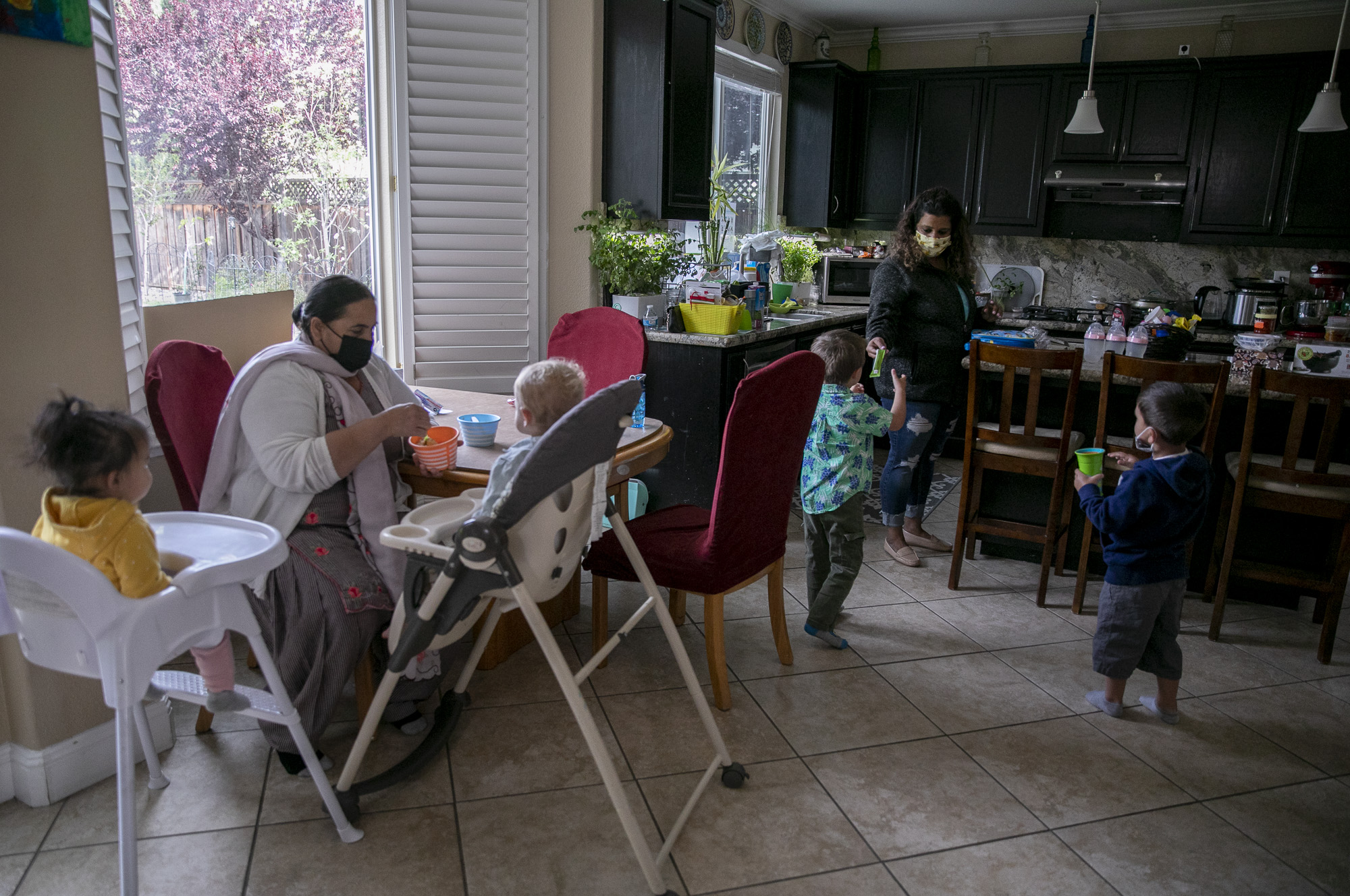 Day care assistant Karamajit Kaur, left, and Shruti Agarwal feed the children breakfast at Shruti Family Day Care in Livermore on April 13, 2021. Photo by Anne Wernikoff, CalMatters