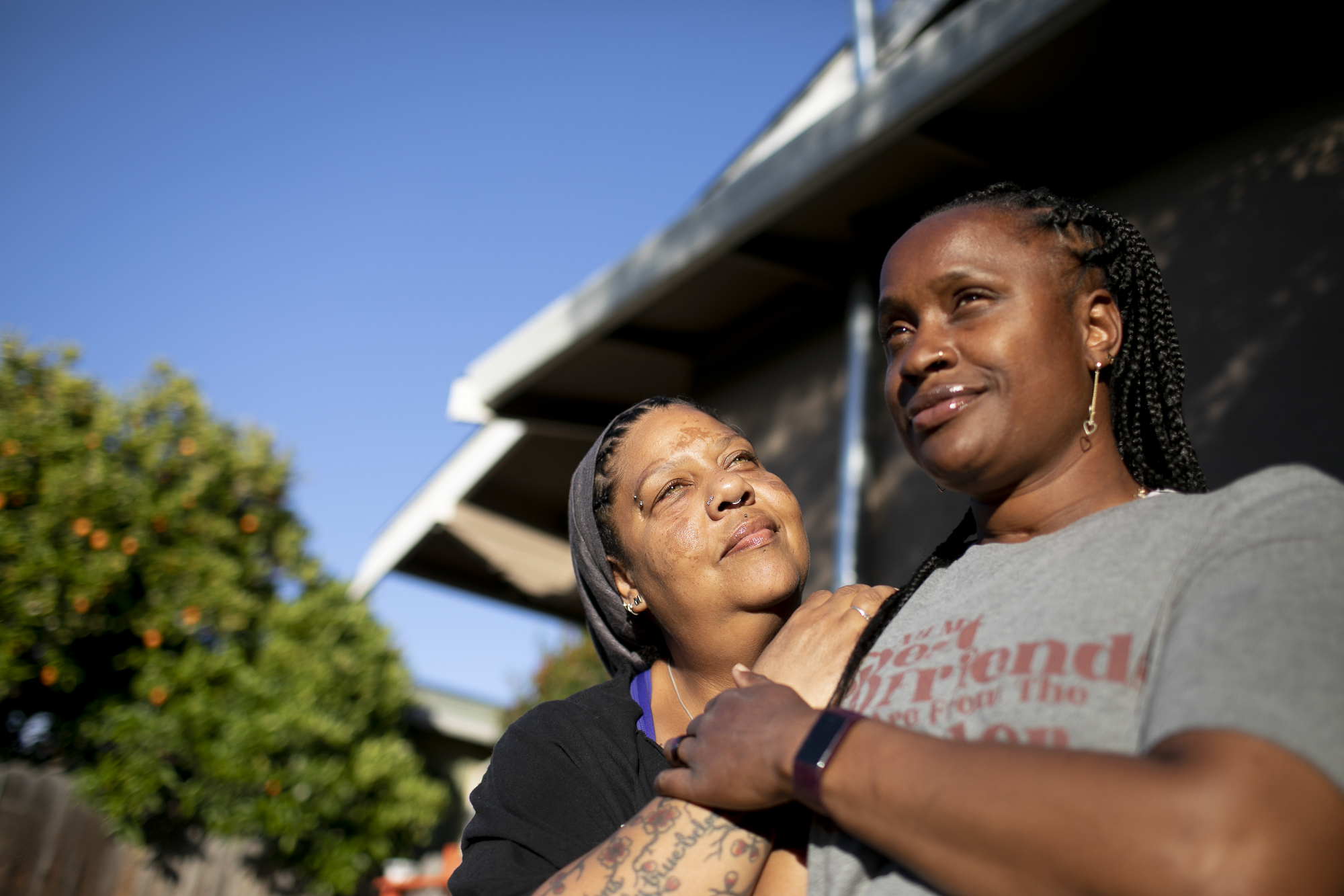 Esther Goolsby, left, and her fiancee, Merika Reagan, at their Oakland home on May 6, 2021. Reagan moved into the home in 2016 and through the Oakland Community land Trust can now work toward purchasing the property outright. Photo by Anne Wernikoff, CalMatters