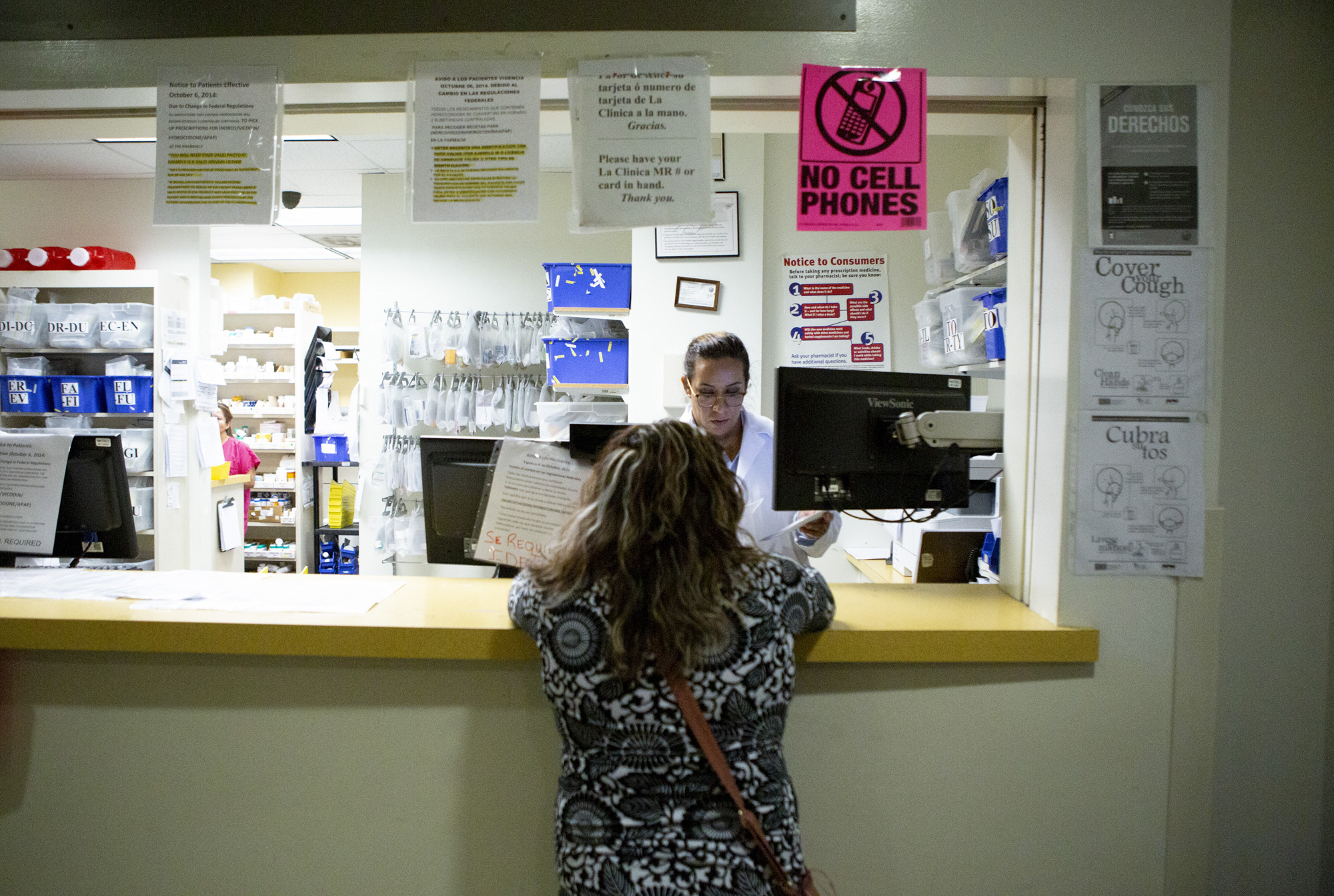 A patient at La Clinica in Oakland picks up her prescription on September 26, 2019. Photo by Anne Wernikoff for CalMatters