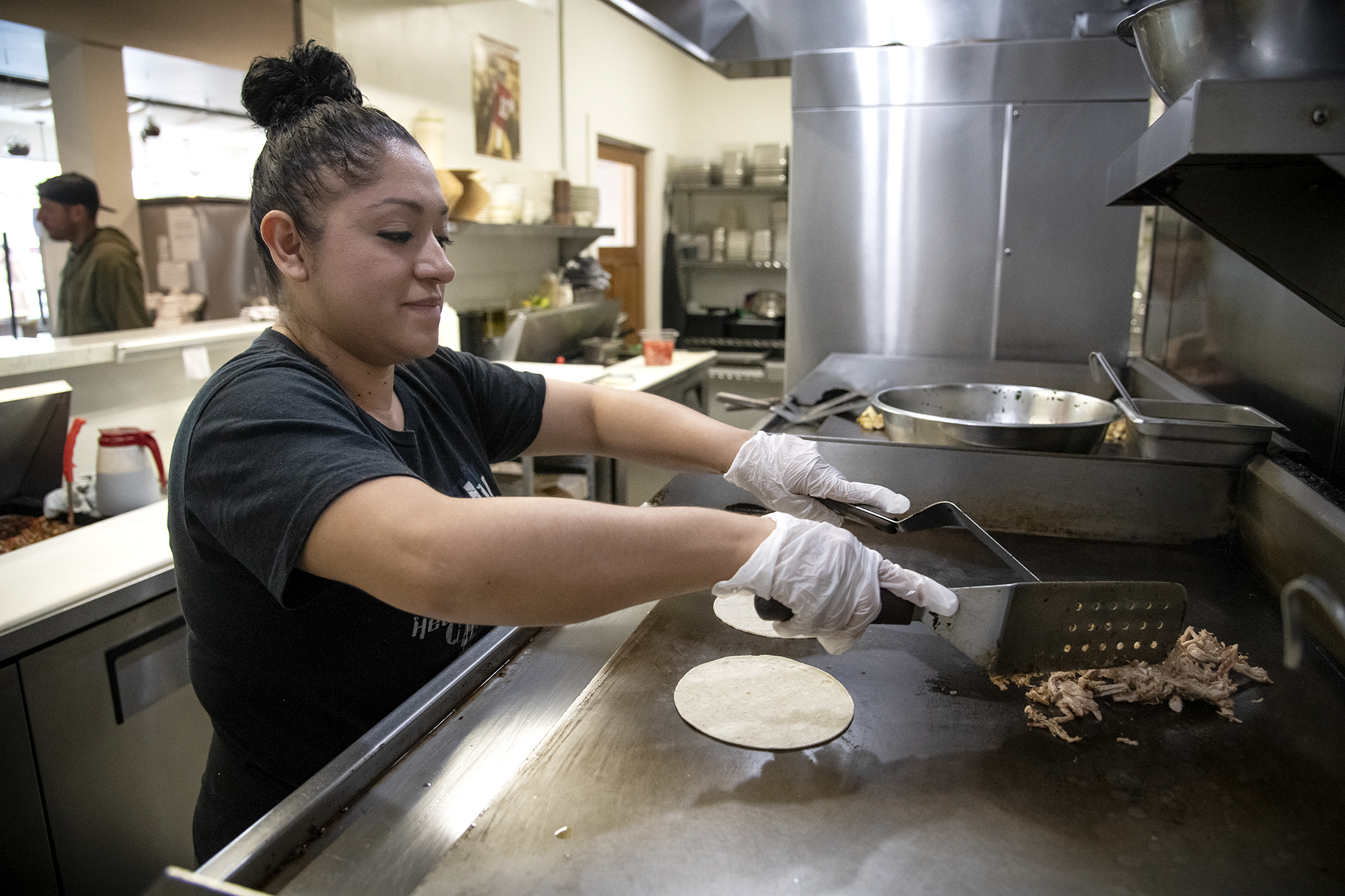 Cook Isaura Martinez preps food in the kitchen at Verde Mexican Rotisserie in South Lake Tahoe on Oct. 6, 2021. Domi Chavarria, the owner of Verde Mexican Rotisserie, lost about $10K worth of inventory when they shut down for two weeks due to the Caldor Fire evacuation. Salgu Wissmath for CalMatters