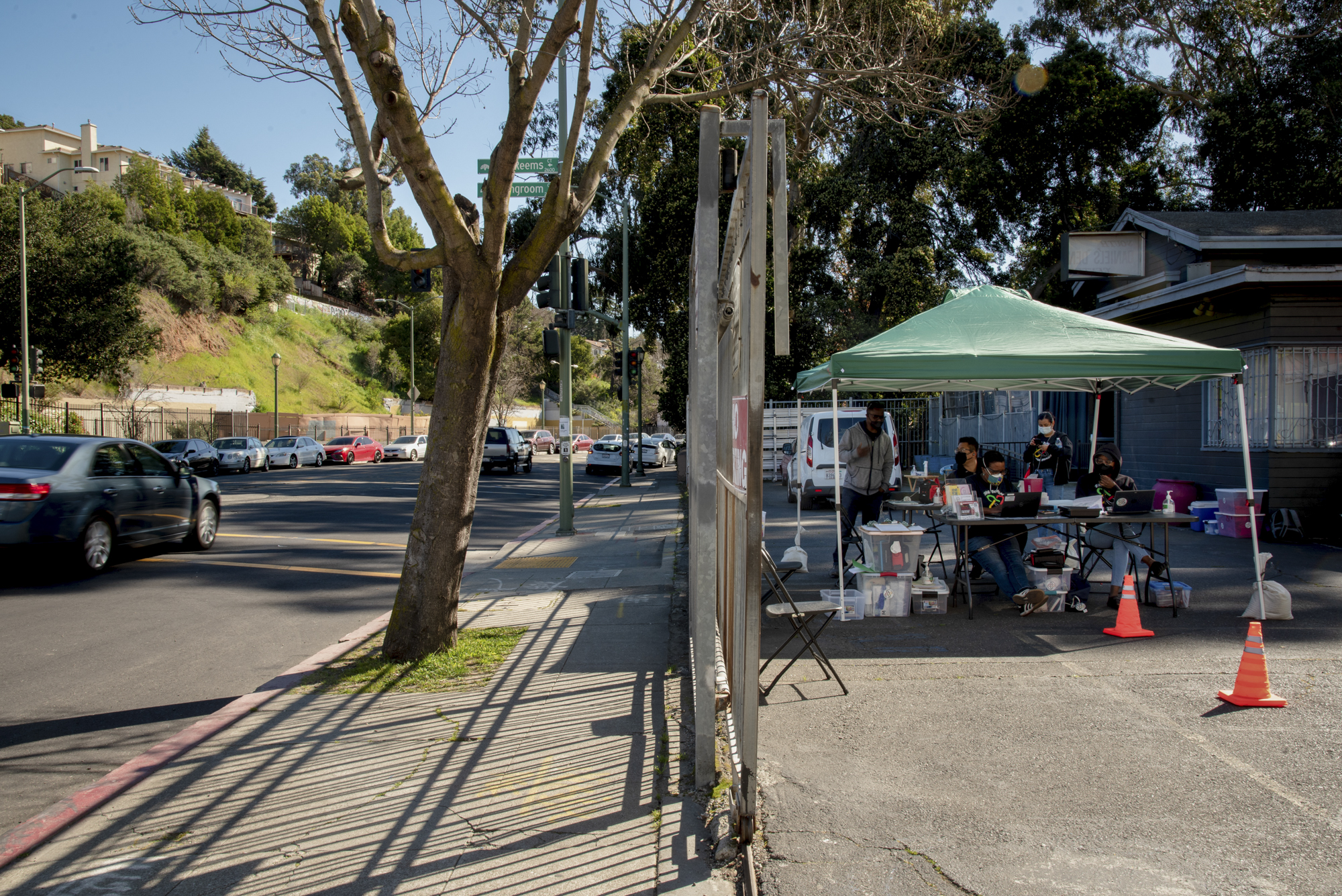 Cars drive past the Umoja Health pop-up clinic in Oakland on Thursday, February 17, 2022. With mask restrictions loosening up in the Bay Area, the clinic has seen less demand for vaccines and COVID-19 testing. Photo by Marissa Leshnov for CalMatters