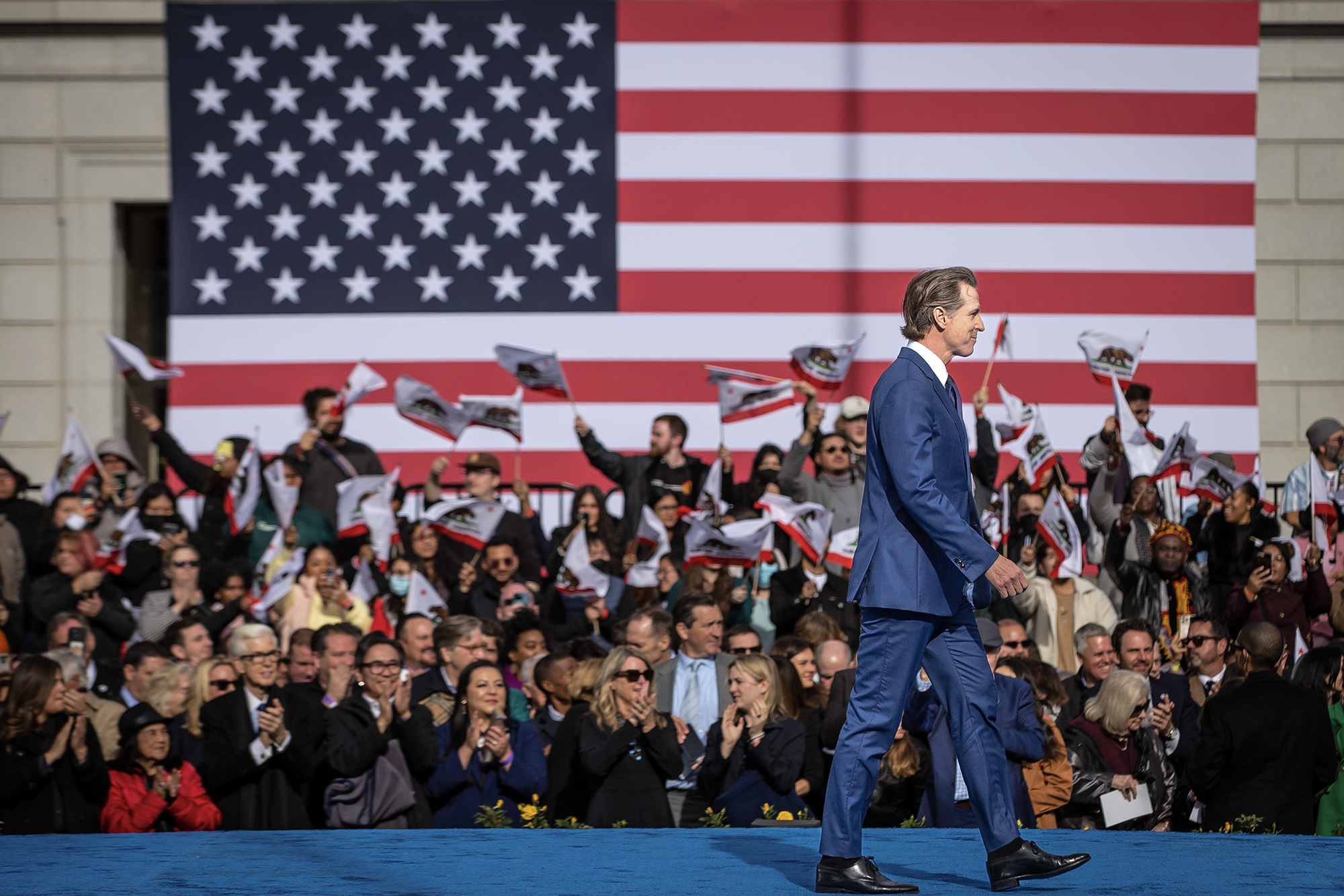 Gov. Gavin Newsom leaves the stage after addressing attendees at his inauguration for a second term at the Plaza de California in Sacramento on Jan. 6, 2023. Photo by Rahul Lal, CalMatters