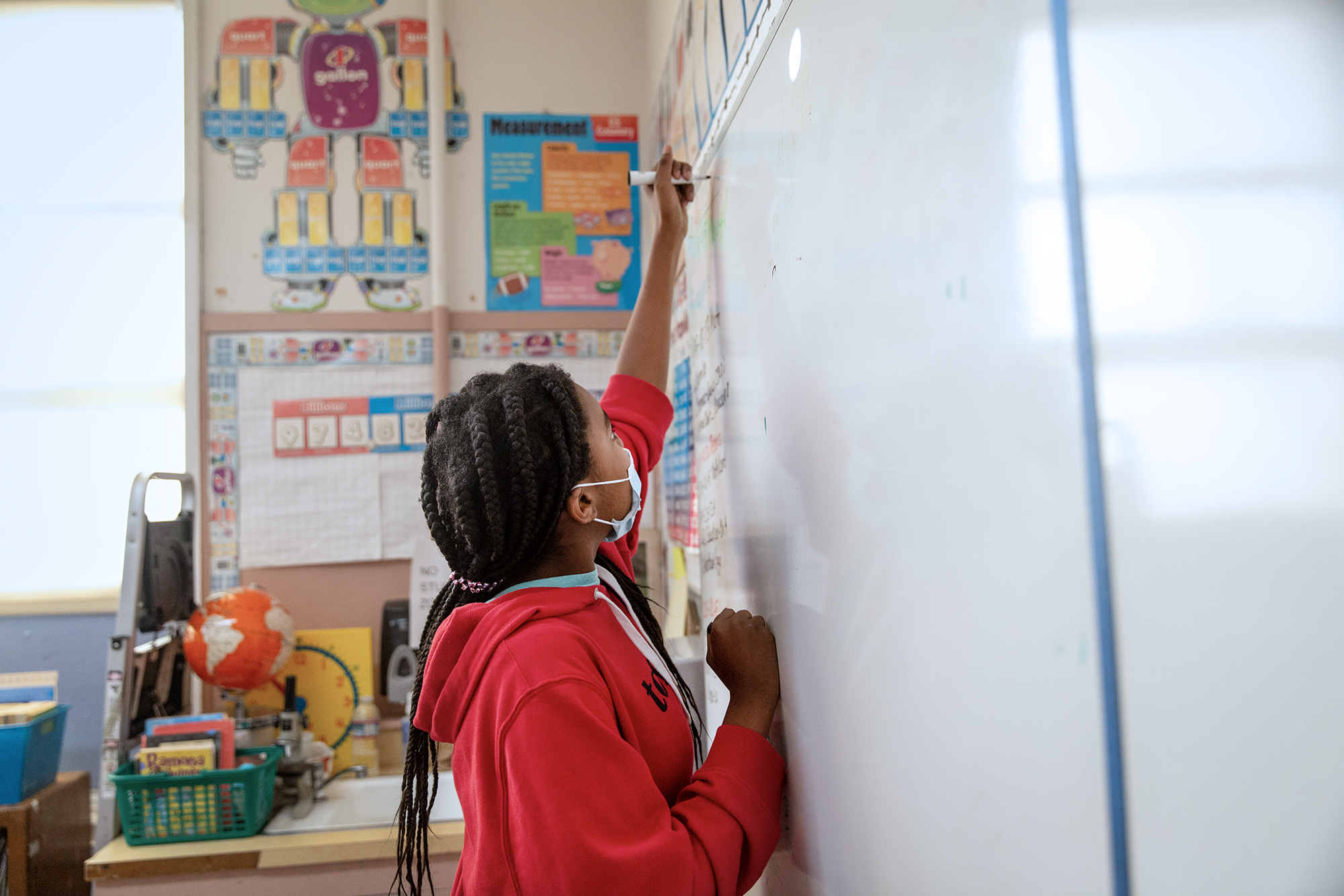 A student writes on a board at Stege Elementary School in Richmond on Feb. 6, 2023. (Photo: Shelby Knowles for CalMatters)