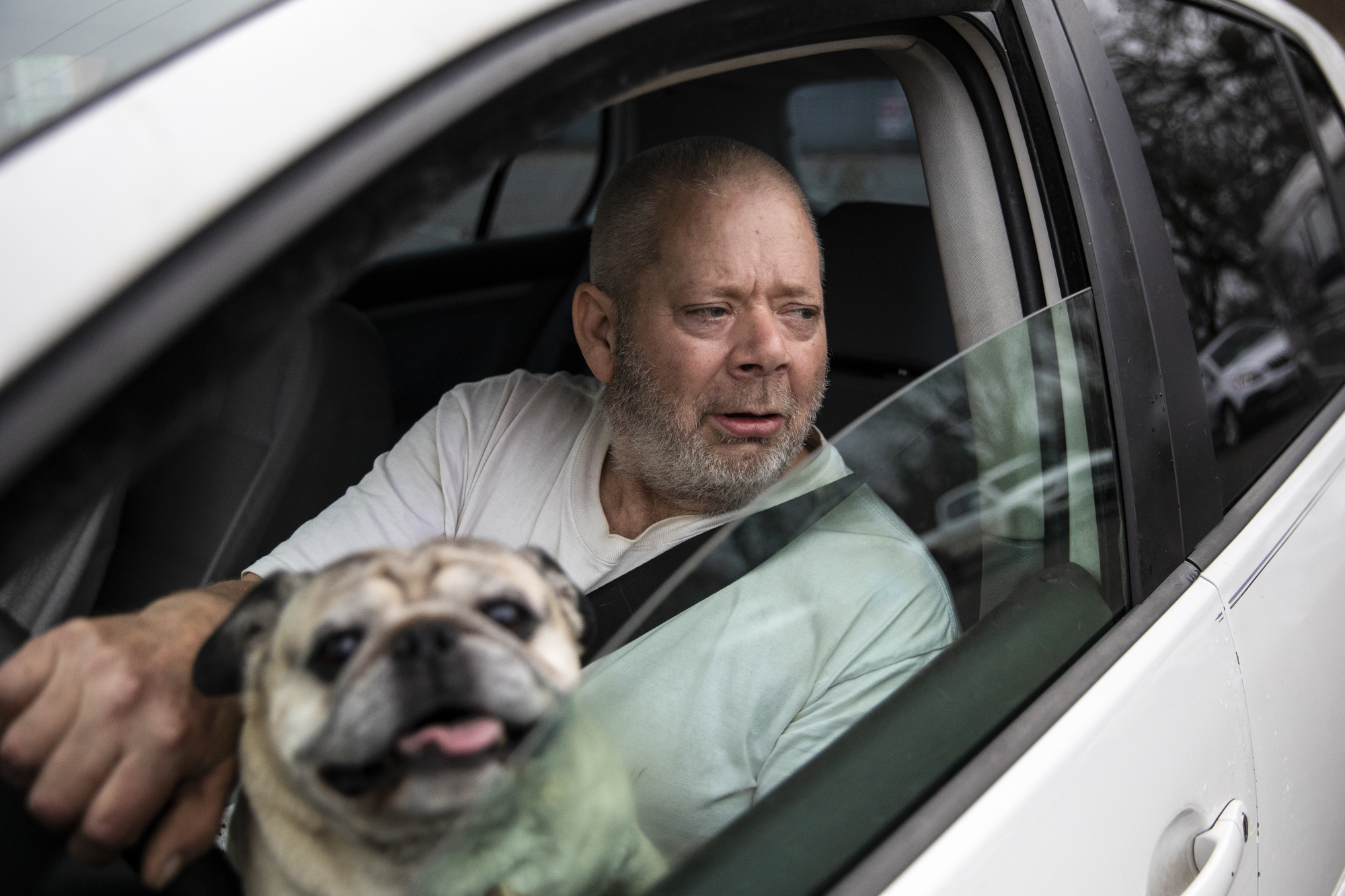 Ira Porter and his dog Biggee wait in line to receive food at the Trinity County Food Bank distribution at the Trinity County Fairgrounds on Feb. 8, 2023.