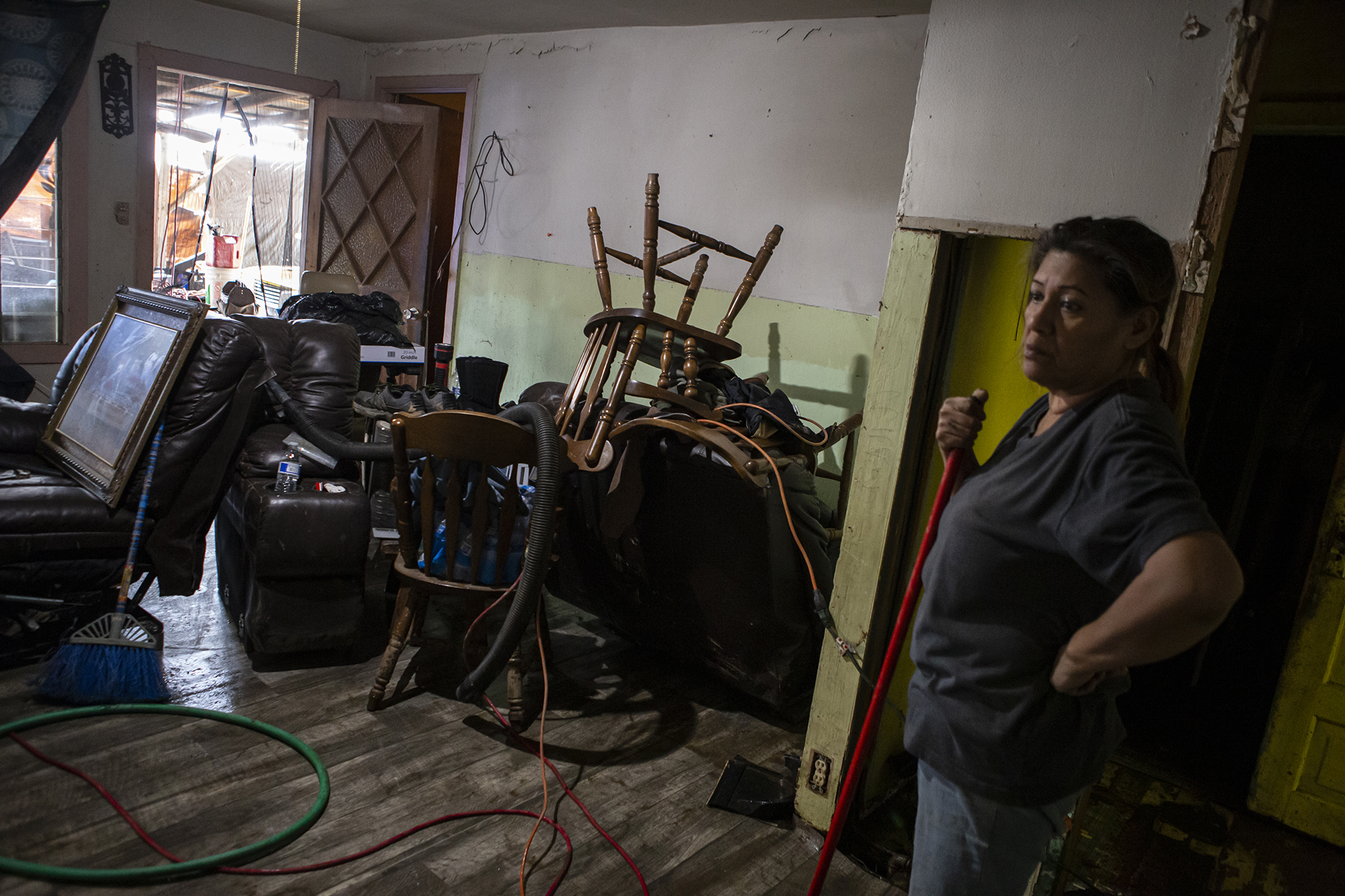 Christina Cabrera cleans out water and mud in her family home after a series of storms on March 12, 2023. Cabrera, who shares the home with her brother Victor Cabrera, said that the home has been in her family for decades and hopes to salvage it. 